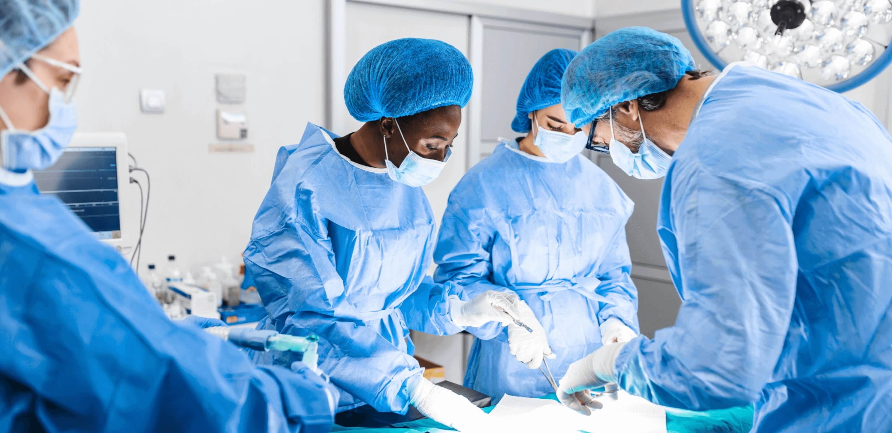 People in surgical masks and scrubs performing surgery together.