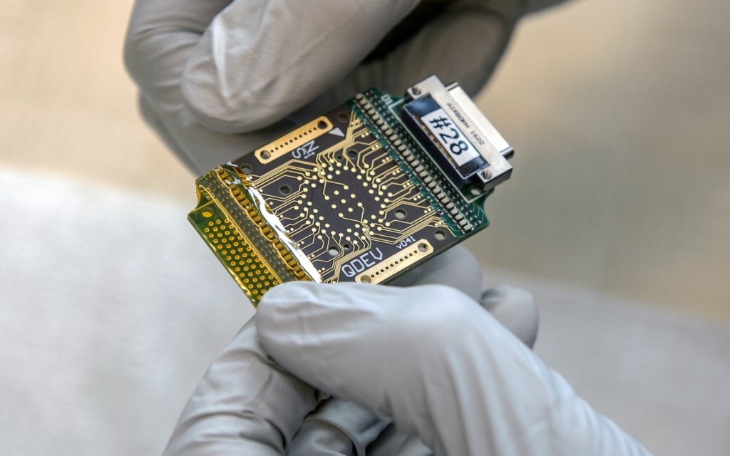 Two hands holding a computer chip
